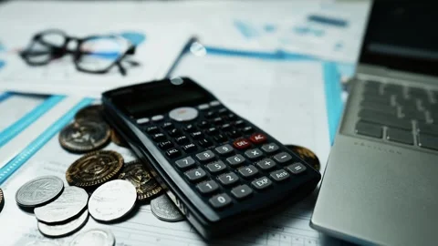 Financial Analysis Workspace with Calculator and Coins, A calculator, coins.. Vídeos de archivo 304960936