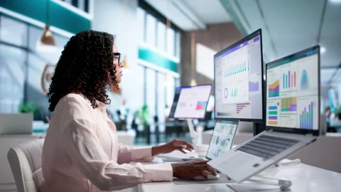 Financial Analyst Reviewing Dashboard Data On Laptop And Desktop Stock Footage 340405475