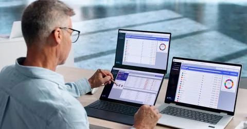 Financial Analyst Studies Rolling Forecast Data Carefully On Dual Touchscreen Stock Photos