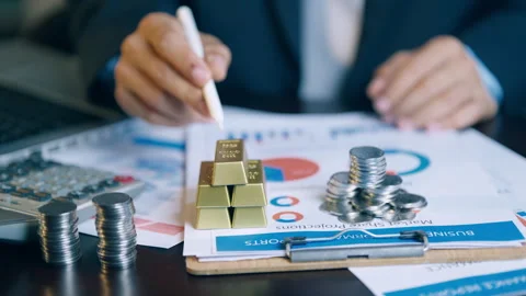 Financial analyst using a pen to check and count gold bars and coins on inv.. Video stock 345941128