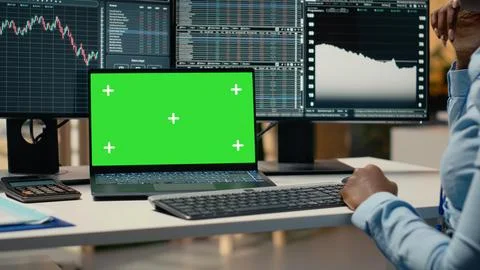 Financial analyst at work doing research using green screen laptop Stock Photos
