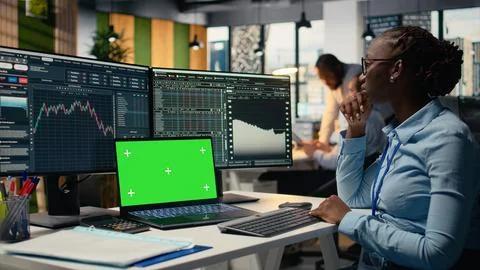 Financial analyst at work doing research using green screen laptop Stock Photos