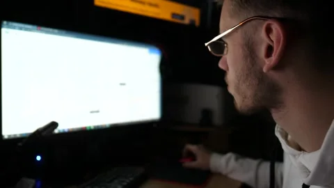 Financial analyst working on computer with multiple monitors at night. Broker Stock Footage 309299867