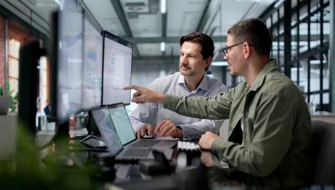 Financial Analysts Collaborate Closely On Laptops Analyzing Cash Flow Trends  Stock Photos