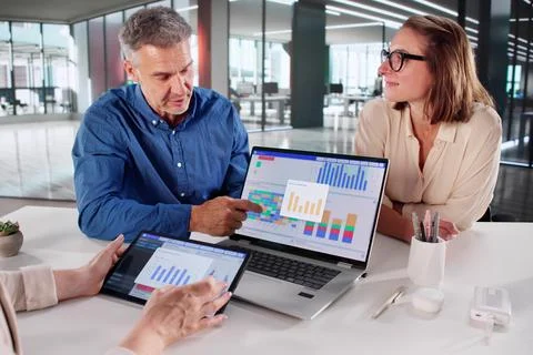 Financial Analysts Discussing Performance Indicators At Multicultural Company 库存照片