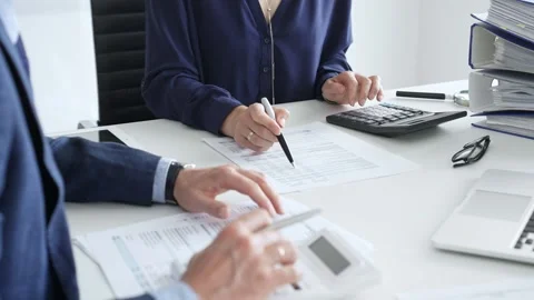 Financial analysts examining documents, using magnifying glass and calculator Stock Footage 316500039