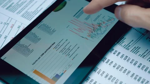 Financial analysts see charts and graphs on the screen of the touchpad Stock Footage