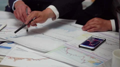 Financial analysts view and discuss stock prices Stock Footage 155606990