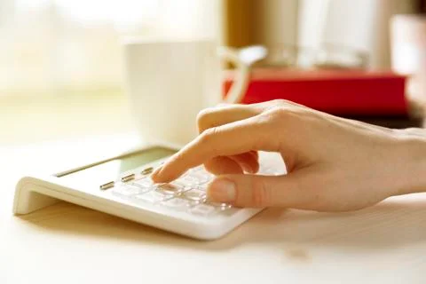 Financial data analyzing hand writing and counting on calculator at home on w Stock Photos