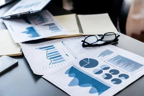 Financial data on digital dashboard papers over wooden table. Fervent Stock Photos