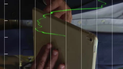Financial data processing against mid section of man using digital tablet at a Stock Footage 312365509