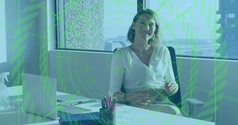 Financial data processing image over businesswoman sitting at office desk 写真素材