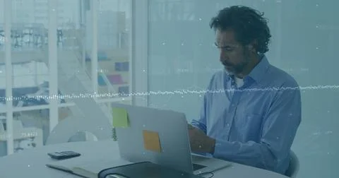 Financial data processing over caucasian man working on laptop in office Stock Photos