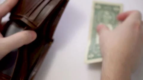 Financial difficulties. A man puts his last dollar in an empty wallet Stock Footage 300939335