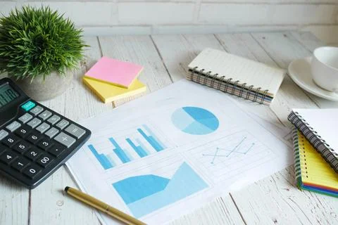 Financial graph, calculator and notepad on table Stock Photos