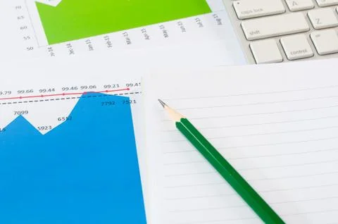 Financial graph chart with notebook and green pencil and  keyboard. business Stock Photos