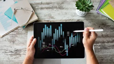 Financial graphs on device screen. Online Investment and stock trading concept. 库存照片