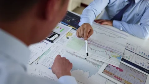 Financial management experts analyze and discuss stock market research repor Stock Footage 234246419