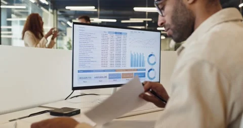 Financial manager analyzing charts and spreadsheet data on office computer Stock-Footage 343466740