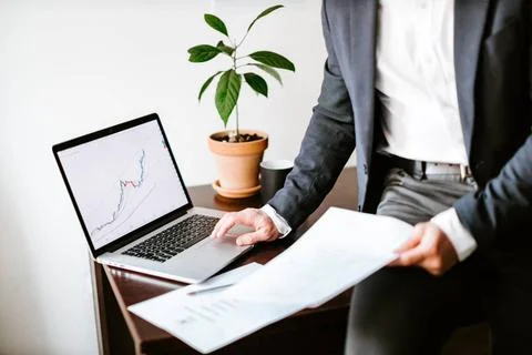 Financial manager analyzing price data trend graph on laptop in office fin... Stock-Fotos