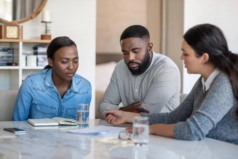 Financial planner going over documents with an African American couple Stock Photos