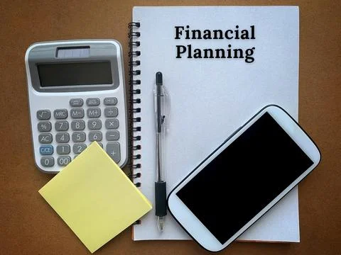 Financial planning text on a notepad with smart phone, pen, calculator and Stock Photos