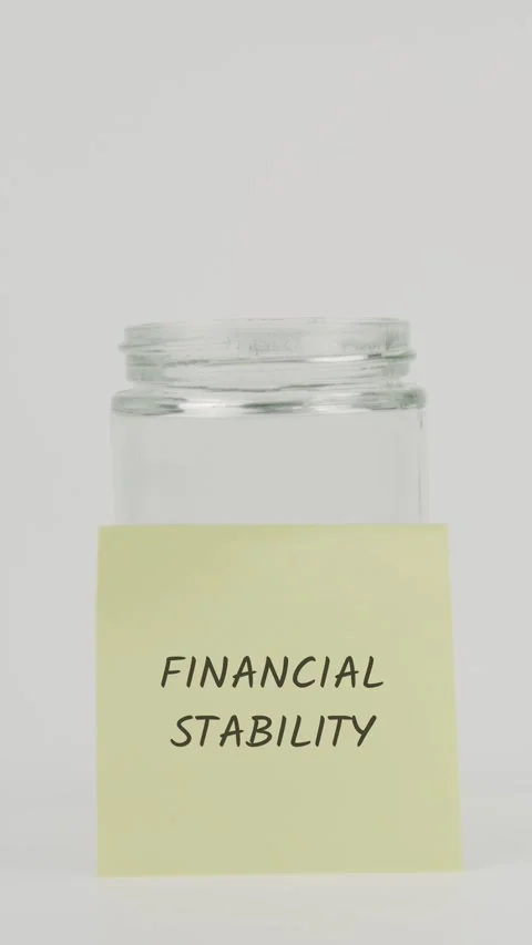 Financial stability text or word on yellow sticky note attached to glass jar Stock Footage 311733411