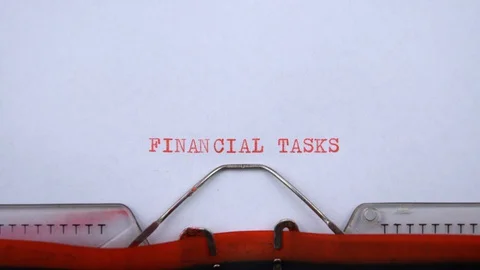 Financial tasks - phrase printed on an old typewriter in red letters, close up. Stock Footage 129535716