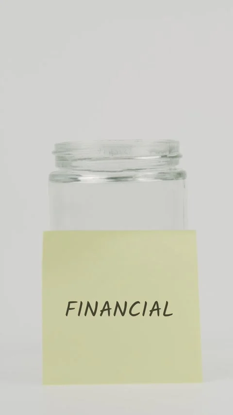 Financial text or word on yellow sticky note attached to glass jar with hand Stock Footage 311733429
