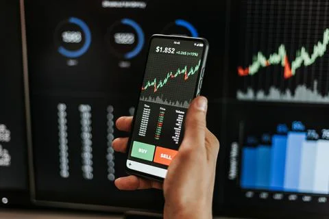 Financial trader man investor using mobile phone app to analyze stock market Stock Photos