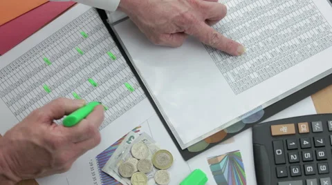 Financier at his desk checking sales reports with a calculator Stock Footage 62082820