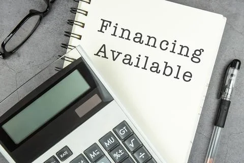 Financing Available text on note pad with calculator Stock Photos