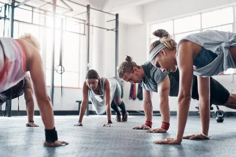 Find a class that works for you. an accountability group doing pushups at the Stock Photos