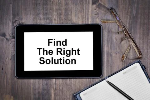Find the right solution. Text on tablet device on desk Stock Photos