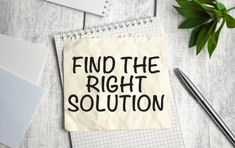 Find The Right Solution text on white notebook and pen on wooden background Stock Photos