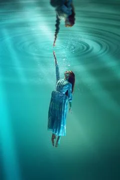 Finding inner self and truth. Poetic underwater scene with elegant young girl Stock Photos