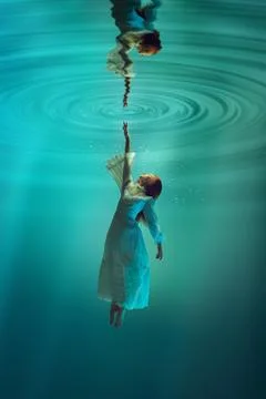 Finding inner self and truth. Poetic underwater scene with elegant young girl Stock Photos