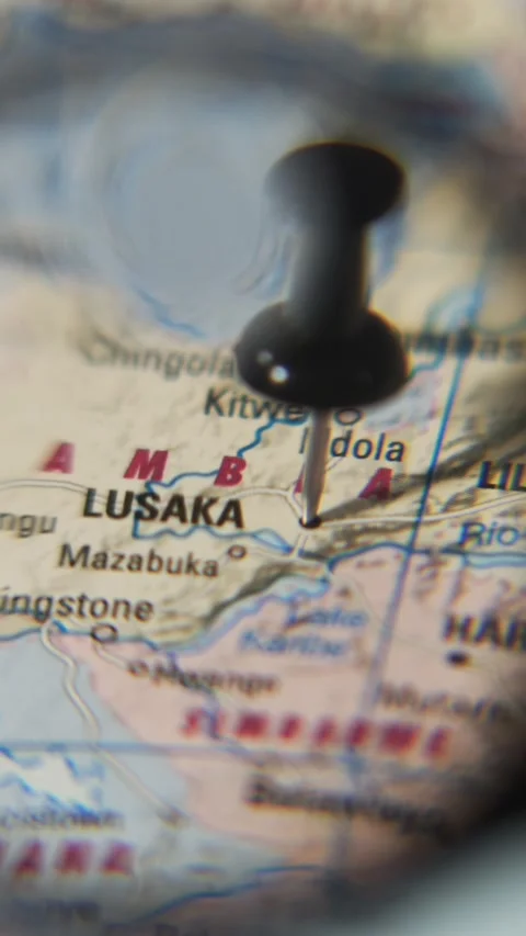 Finding Lusaka on a printed map using a magnifying glass Stock Footage 339303757