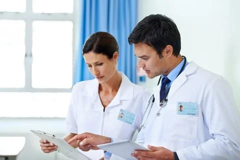 Finding the root of their patients problem. a handsome young doctor and nursing Stock Photos