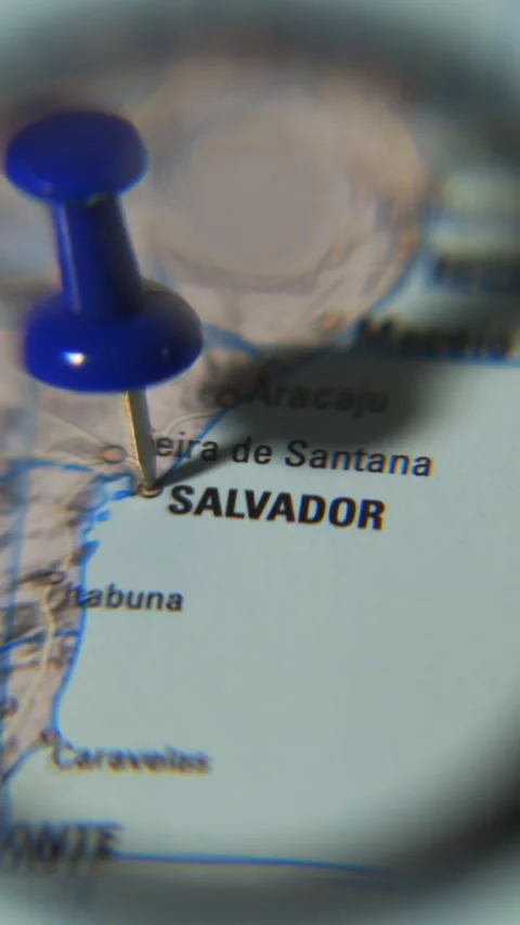 Finding Salvador on a printed map using a magnifying glass Stock Footage 339303763