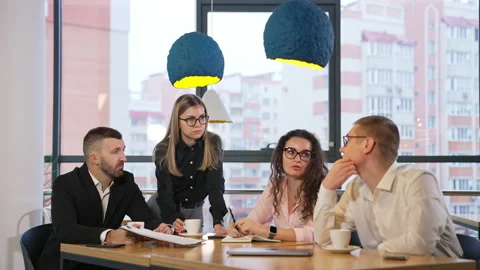Finding solutions to the problems. Office team gathered at the table to discuss  Stock Footage 196899485