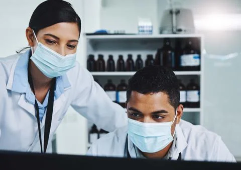 Finding solutions to real life problems. two young researchers using a computer Stockfoto's