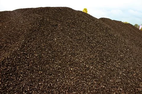 Fine charcoal for heating is dumped in a big pile Stock Photos
