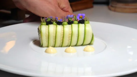 Fine dining chef arranging artfully plated gourmet dish with sliced Stock Footage 281100376
