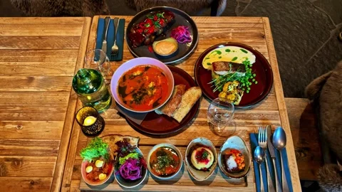 Fine dining experience with various traditional dishes for two people in a cozy Stock Footage 341544161