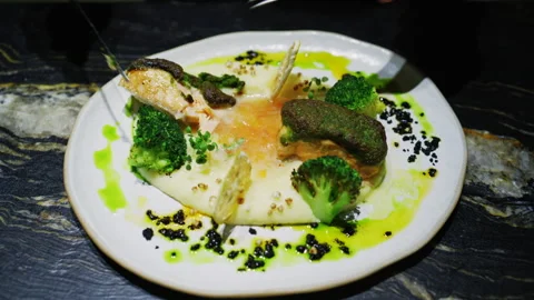 Fine dining plated fish dish with broccoli, creamy puree, herbs, and green sauce Stock Footage 331009317