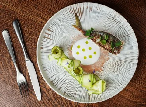 Fine Dining Presentation of Cooked Fish with Crispy Skin and Creamy Sauce.. Stock Photos