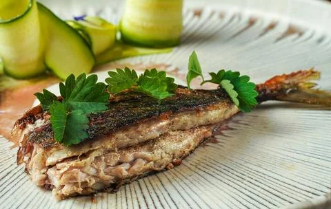 Fine Dining Presentation of Cooked Fish with Crispy Skin and Creamy Sauce.. Stock Photos