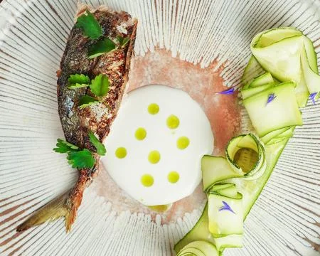 Fine Dining Presentation of Cooked Fish with Crispy Skin and Creamy Sauce.. Stock Photos