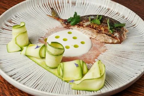 Fine Dining Presentation of Cooked Fish with Crispy Skin and Creamy Sauce.. Stock Photos